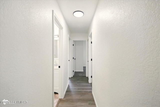557 N Glenn Hwy, Palmer, AK 99645 - hallway featuring a textured wall, light wood-style floors, and baseboards