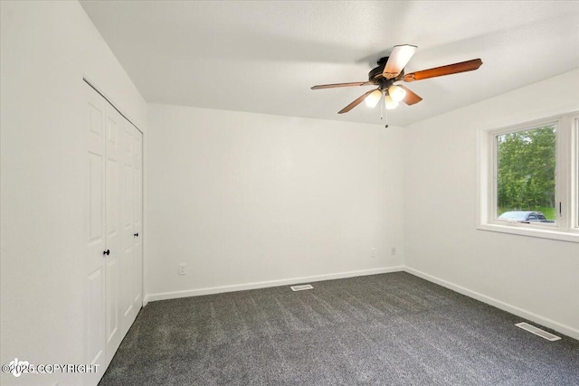 557 N Glenn Hwy, Palmer, AK 99645 - unfurnished bedroom with dark carpet, baseboards, a closet, and a ceiling fan