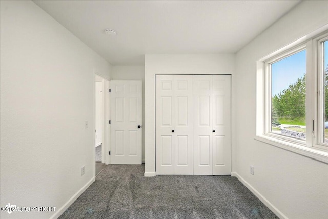 557 N Glenn Hwy, Palmer, AK 99645 - unfurnished bedroom with dark colored carpet, baseboards, and a closet