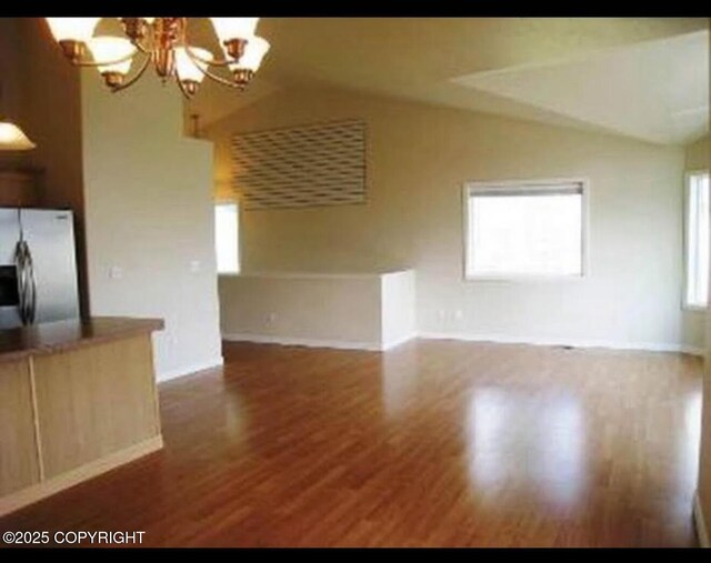 7252 Glade Pl # 4, Anchorage, AK 99518 - unfurnished living room with vaulted ceiling, a chandelier, and wood finished floors