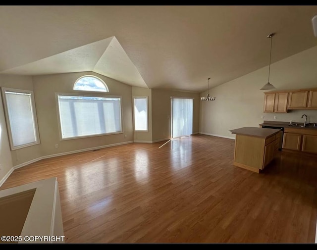 7252 Glade Pl # 4, Anchorage, AK 99518 - unfurnished living room featuring vaulted ceiling, wood finished floors, and a chandelier