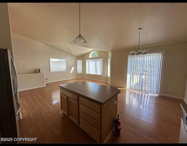 7252 Glade Pl # 4, Anchorage, AK 99518 - kitchen with freestanding refrigerator, open floor plan, wood finished floors, a chandelier, and dark countertops