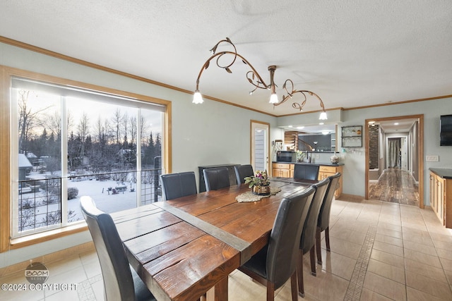 4745 Manytell Ave, Anchorage, AK 99516 - dining room with a chandelier, crown molding, a textured ceiling, light tile patterned floors, and baseboards