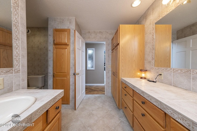 4745 Manytell Ave, Anchorage, AK 99516 - bathroom with vanity, tile patterned floors, a textured ceiling, and decorative backsplash