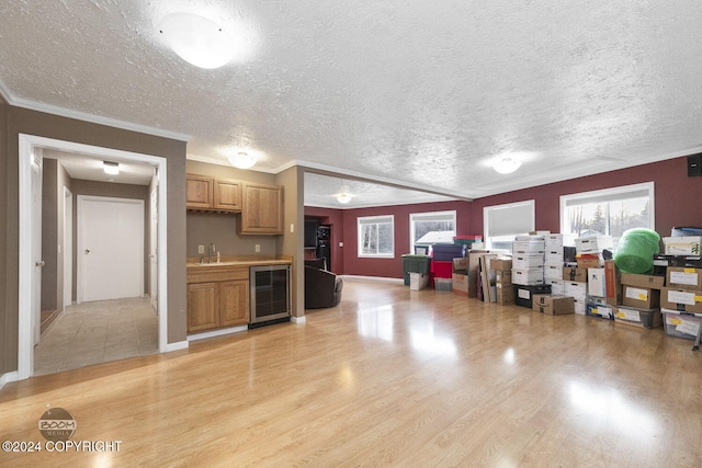 4745 Manytell Ave, Anchorage, AK 99516 - kitchen featuring wine cooler, a sink, light wood-style floors, plenty of natural light, and a textured ceiling