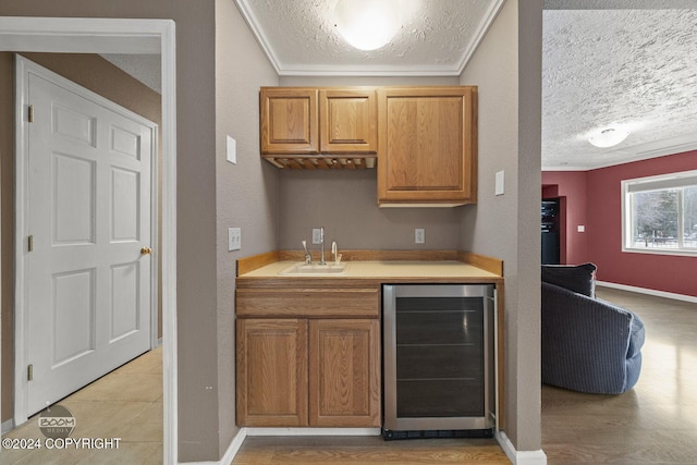 4745 Manytell Ave, Anchorage, AK 99516 - indoor wet bar featuring wine cooler, a textured ceiling, baseboards, and crown molding