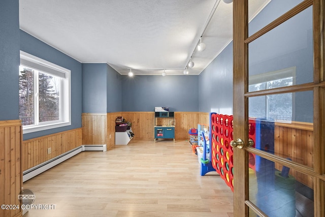 4745 Manytell Ave, Anchorage, AK 99516 - rec room with a wainscoted wall, baseboard heating, rail lighting, wood finished floors, and wood walls