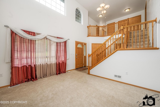 118 S Vickie Cir, Palmer, AK 99645 - unfurnished living room with stairs, carpet flooring, baseboards, a chandelier, and a towering ceiling