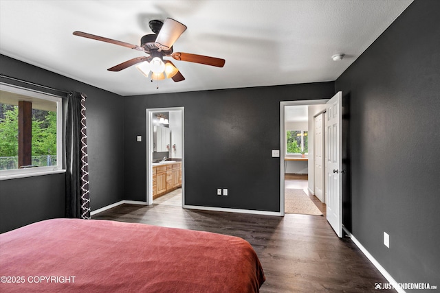 7490 W Rodney Cir, Wasilla, AK 99623 - bedroom with dark wood-style flooring, baseboards, ensuite bathroom, and a ceiling fan