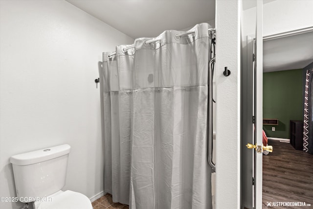 7490 W Rodney Cir, Wasilla, AK 99623 - bathroom featuring toilet, baseboards, and a shower with shower curtain