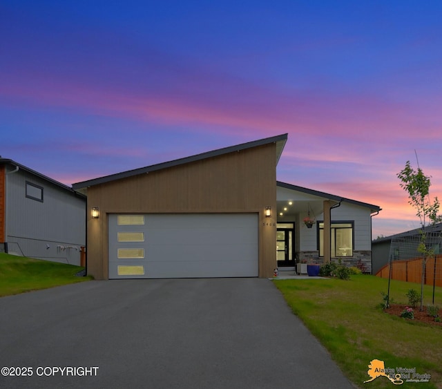 5466 Sandhill Loop, Anchorage, AK 99502 - view of front of home featuring driveway, an attached garage, and stone siding