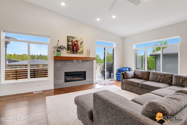 5466 Sandhill Loop, Anchorage, AK 99502 - living area featuring vaulted ceiling, wood finished floors, a brick fireplace, recessed lighting, and ceiling fan