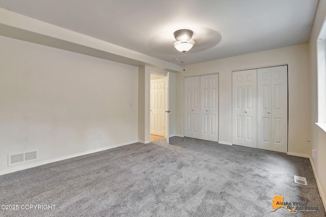 2598 Brookshire Loop # 27, Anchorage, AK 99504 - unfurnished bedroom featuring multiple closets and carpet flooring