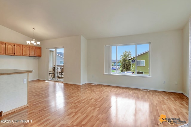 2598 Brookshire Loop # 27, Anchorage, AK 99504 - unfurnished living room with a chandelier, light wood-style flooring, and lofted ceiling