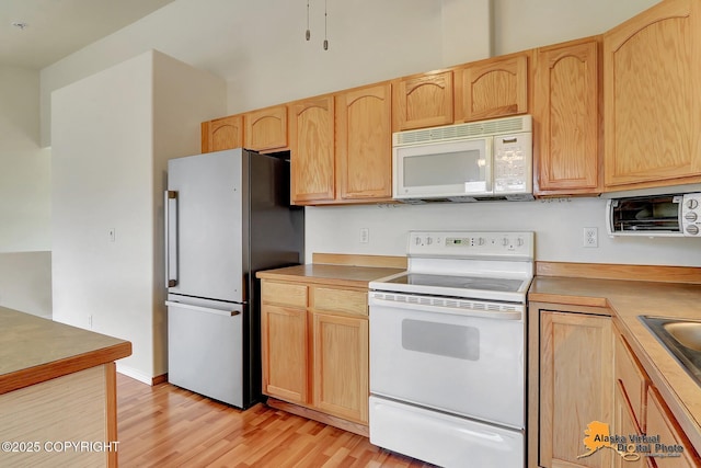 2598 Brookshire Loop # 27, Anchorage, AK 99504 - kitchen with white appliances, light brown cabinets, light wood-type flooring, and light countertops