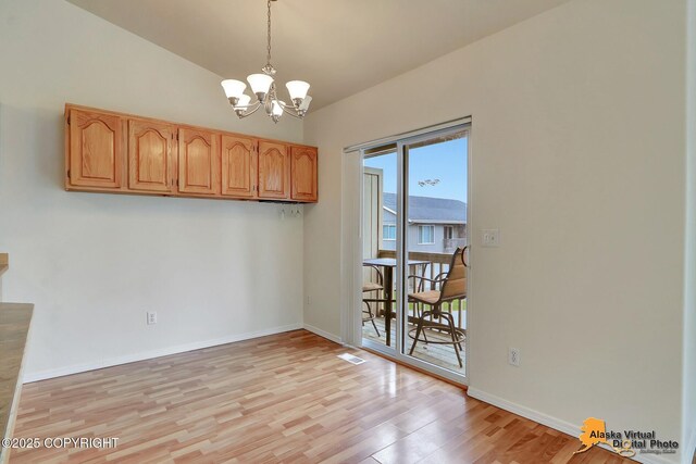 2598 Brookshire Loop # 27, Anchorage, AK 99504 - unfurnished dining area with a chandelier, light wood-style floors, and lofted ceiling