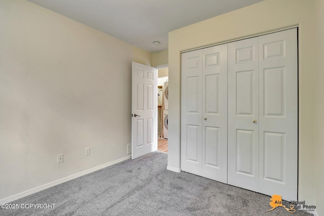 2598 Brookshire Loop # 27, Anchorage, AK 99504 - unfurnished bedroom featuring stacked washer / dryer, carpet flooring, and a closet