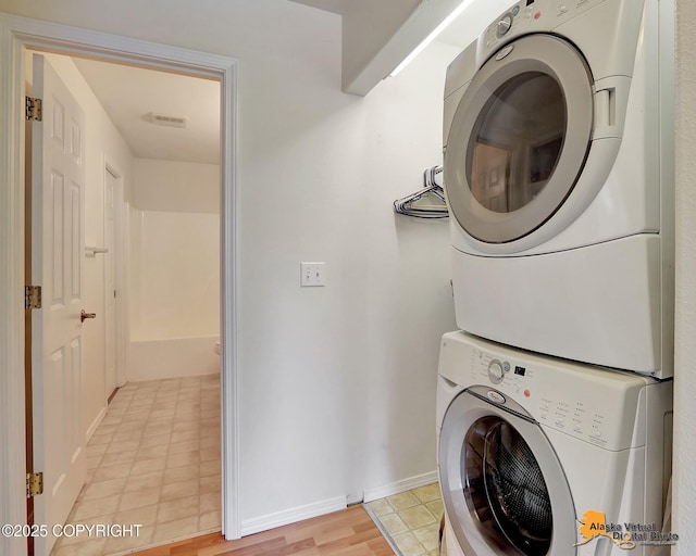 2598 Brookshire Loop # 27, Anchorage, AK 99504 - washroom with stacked washer and clothes dryer and light tile patterned floors