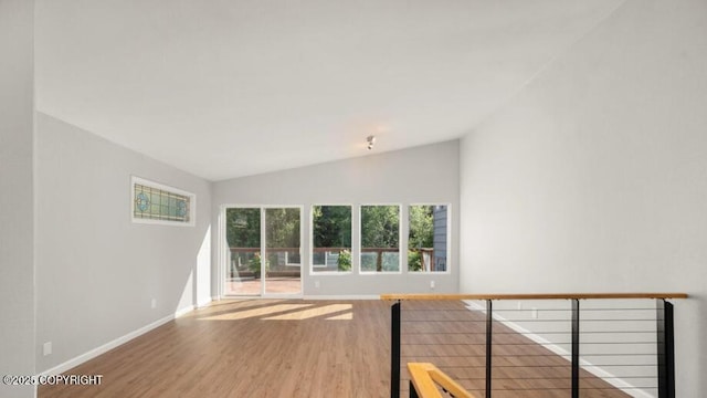 2551 La Honda Dr, Anchorage, AK 99517 - unfurnished room featuring lofted ceiling, wood finished floors, and baseboards