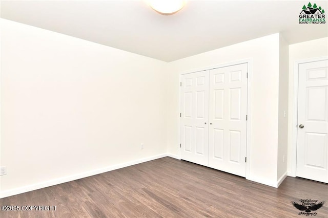 310 Park Way N, Pole, AK 99705 - unfurnished bedroom with dark wood-style flooring, baseboards, and a closet
