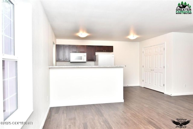 310 Park Way N, Pole, AK 99705 - kitchen with white microwave, fridge, dark wood-type flooring, dark brown cabinetry, and a peninsula