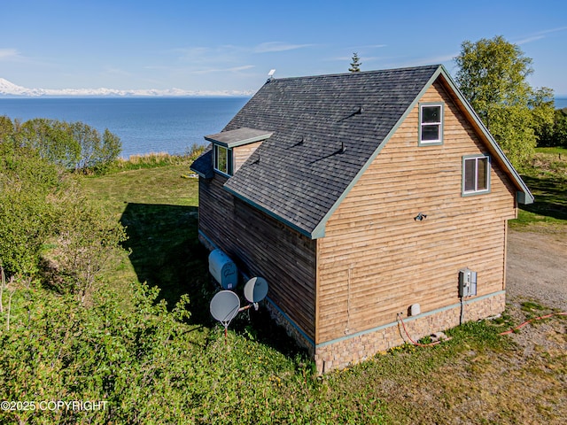 11091 Crestline Ln, Clam Gulch, AK 99568 - view of property exterior with a water view, roof with shingles, and a lawn
