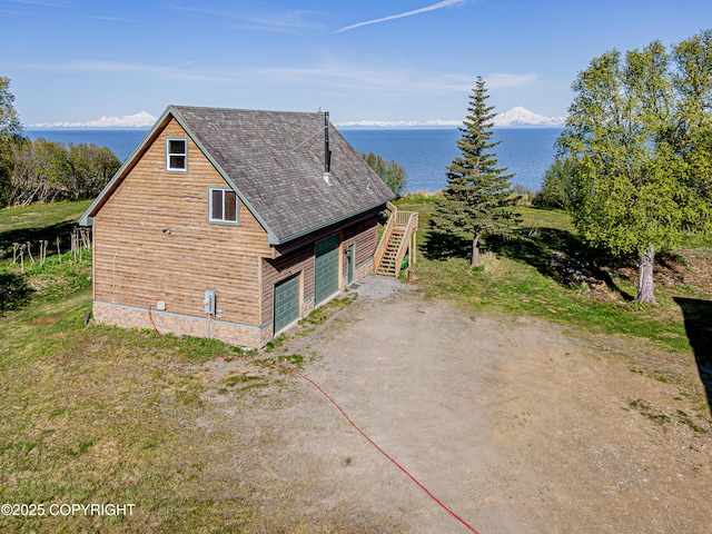 11091 Crestline Ln, Clam Gulch, AK 99568 - view of property exterior with a water view, a garage, roof with shingles, and stairway