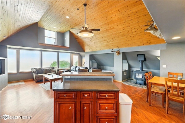 11091 Crestline Ln, Clam Gulch, AK 99568 - kitchen with open floor plan, a wood stove, high vaulted ceiling, ceiling fan, and dark brown cabinets