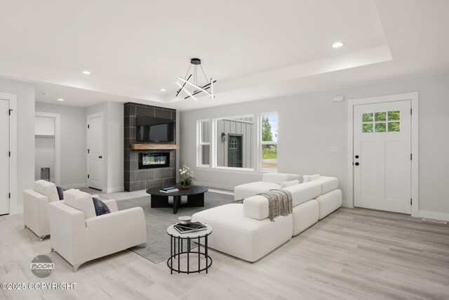 8328 S Ira Dr, Wasilla, AK 99623 - living room with a raised ceiling, a chandelier, wood finished floors, recessed lighting, and a fireplace