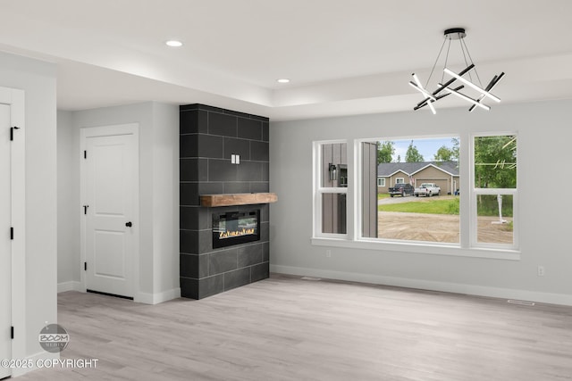 8328 S Ira Dr, Wasilla, AK 99623 - unfurnished living room featuring wood finished floors, a fireplace, recessed lighting, and a chandelier