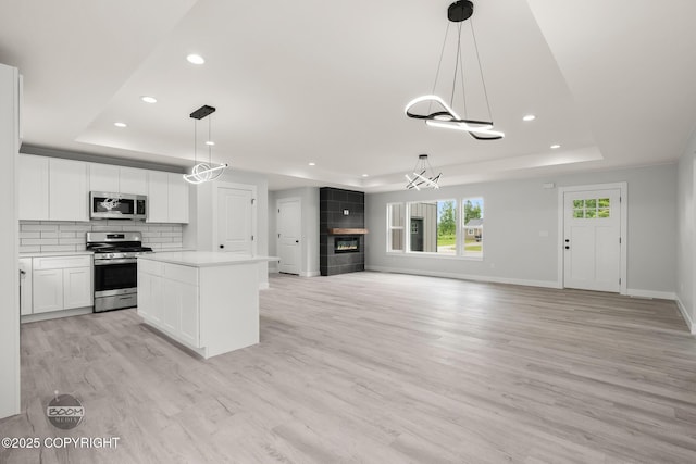 8328 S Ira Dr, Wasilla, AK 99623 - kitchen with appliances with stainless steel finishes, a raised ceiling, recessed lighting, a chandelier, and light wood finished floors