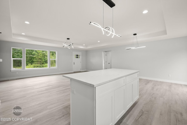 8328 S Ira Dr, Wasilla, AK 99623 - kitchen with a raised ceiling, white cabinets, light wood-style flooring, a kitchen island, and recessed lighting