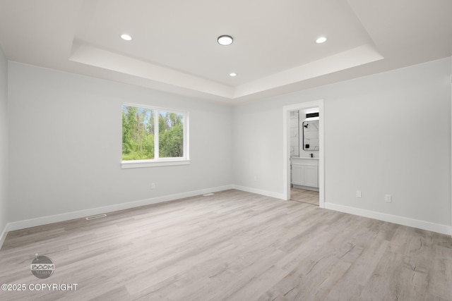 8328 S Ira Dr, Wasilla, AK 99623 - empty room featuring a raised ceiling, light wood-style floors, and recessed lighting