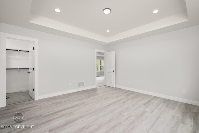 8328 S Ira Dr, Wasilla, AK 99623 - unfurnished bedroom with a tray ceiling, recessed lighting, wood finished floors, and a spacious closet