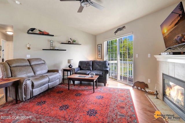 201 E Danna Ave Unit D, Wasilla, AK 99654 - living area featuring vaulted ceiling, wood finished floors, a tiled fireplace, and a ceiling fan