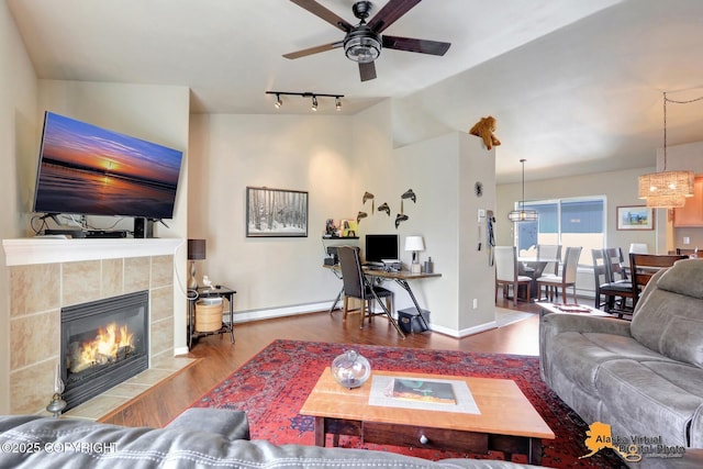 201 E Danna Ave Unit D, Wasilla, AK 99654 - living area with baseboard heating, ceiling fan, wood finished floors, a fireplace, and lofted ceiling