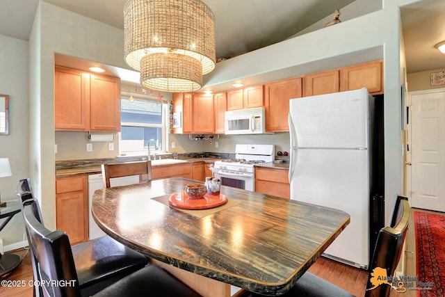 201 E Danna Ave Unit D, Wasilla, AK 99654 - kitchen featuring white appliances, light brown cabinetry, wood finished floors, a sink, and a kitchen breakfast bar
