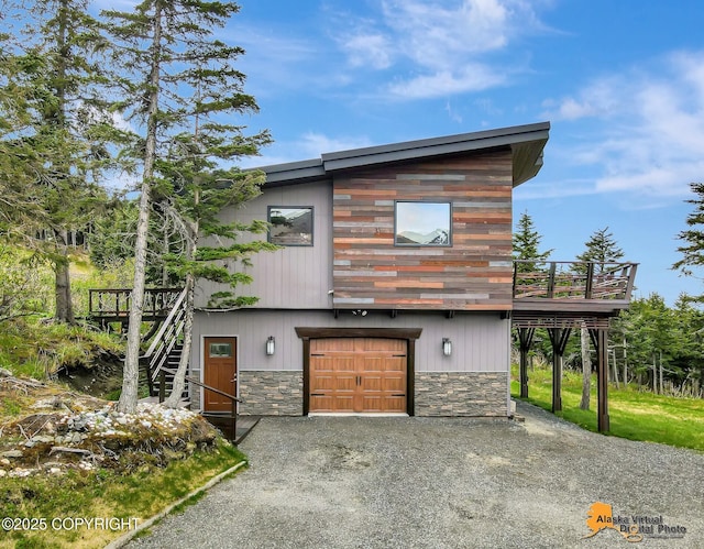 17132 Carl St, Anchorage, AK 99516 - view of front facade featuring stone siding, an attached garage, stairway, a wooden deck, and driveway