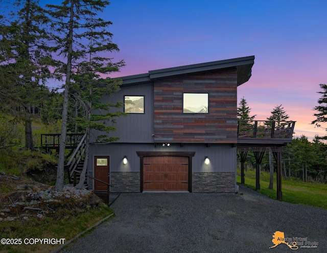 17132 Carl St, Anchorage, AK 99516 - contemporary home featuring an attached garage, stone siding, a wooden deck, and stairway