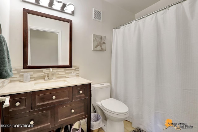 17132 Carl St, Anchorage, AK 99516 - bathroom featuring toilet, vanity, and decorative backsplash