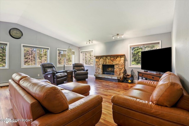 9701 Homestead Trl, Anchorage, AK 99507 - living area with lofted ceiling, hardwood / wood-style flooring, a fireplace, and a baseboard heating unit