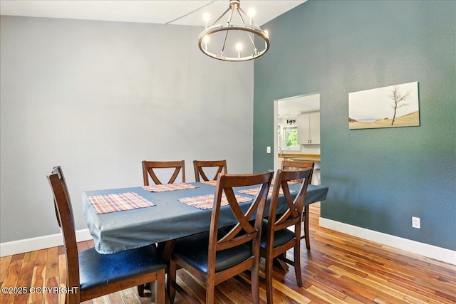 9701 Homestead Trl, Anchorage, AK 99507 - dining space with a chandelier, wood finished floors, baseboards, and a towering ceiling
