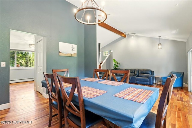 9701 Homestead Trl, Anchorage, AK 99507 - dining room featuring a baseboard radiator, a chandelier, wood finished floors, and stairs