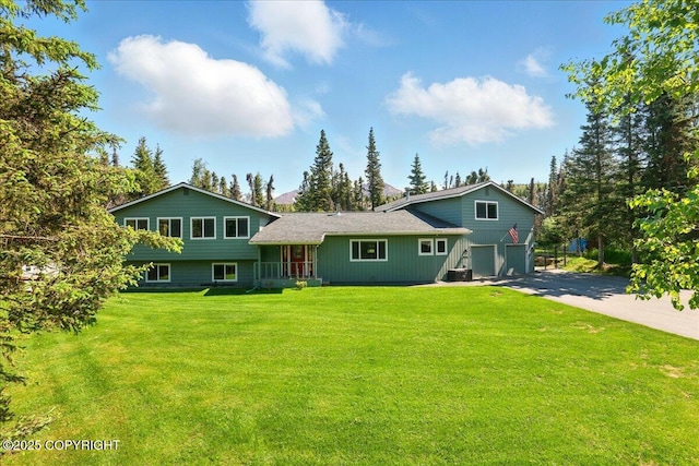 9701 Homestead Trl, Anchorage, AK 99507 - back of house featuring a garage, driveway, and a yard