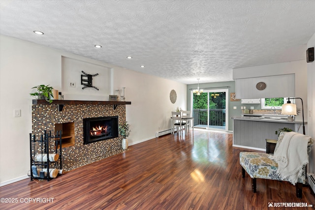 11730 Nix Ct, Anchorage, AK 99515 - living area featuring dark wood-style flooring, a tiled fireplace, a textured ceiling, baseboards, and recessed lighting