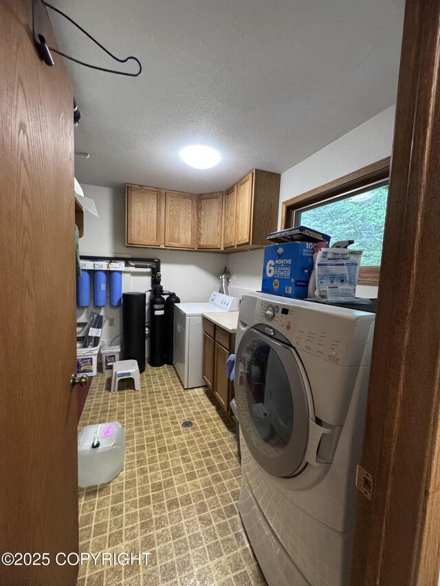 34008 Orlander Ave, Seward, AK 99664 - laundry room with cabinet space, a textured ceiling, and washing machine and clothes dryer
