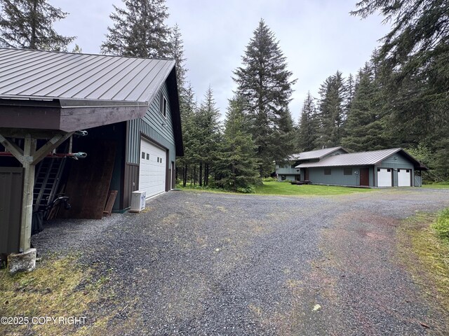 34008 Orlander Ave, Seward, AK 99664 - view of side of home featuring a standing seam roof, a garage, an outbuilding, and metal roof
