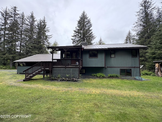 34008 Orlander Ave, Seward, AK 99664 - back of property with stairway, a lawn, metal roof, a chimney, and a deck