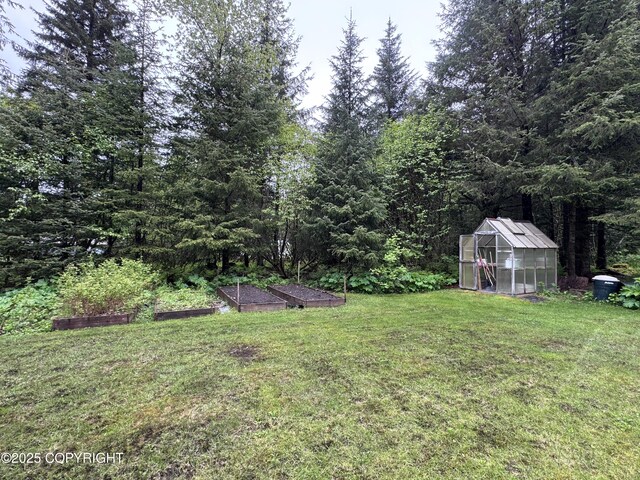 34008 Orlander Ave, Seward, AK 99664 - view of grassy yard with an exterior structure, a garden, and an outbuilding