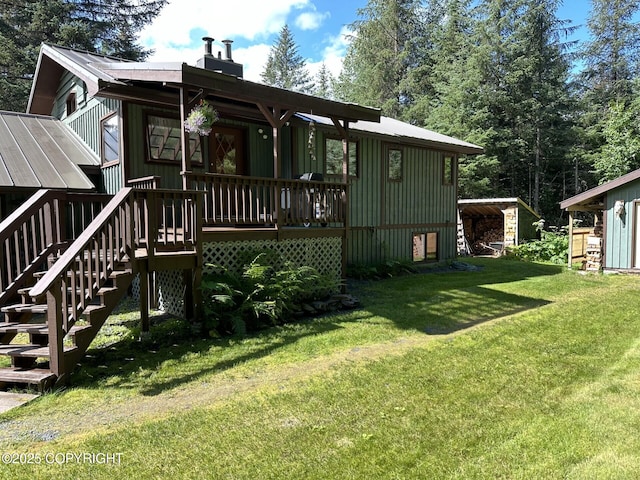 34008 Orlander Ave, Seward, AK 99664 - rear view of house with a lawn, stairway, a deck, and a chimney